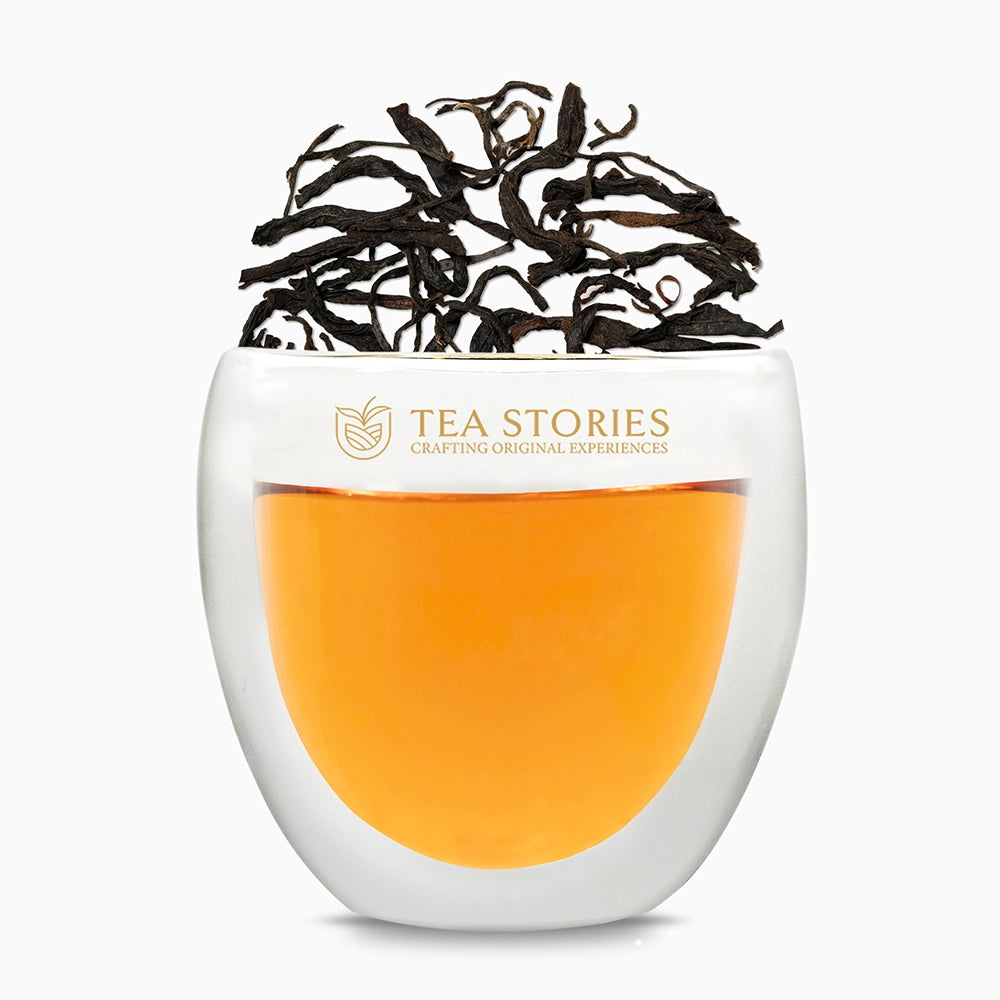 Teastories: Premium black tea leaves and brewed liquor in signature glass.