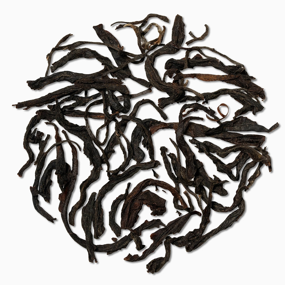 Orthodox black tea leaves on white surface — showcasing Palar Onyx's earthy character.