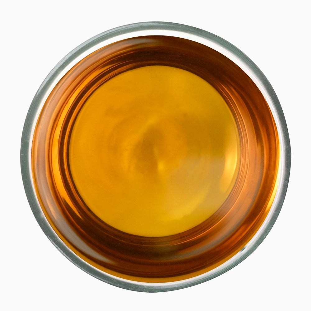 White bowl with vibrant orange liquid — Lockhart Noir premium tea visual.