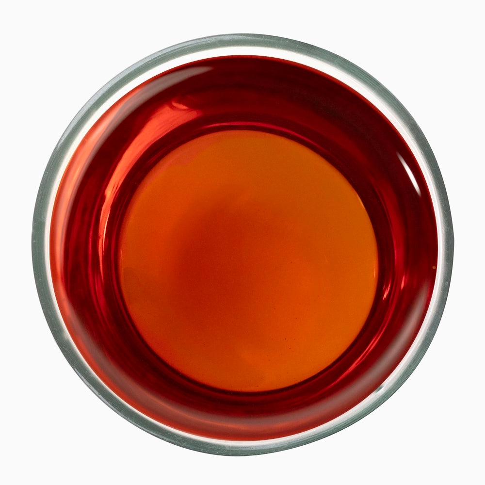 Dark orange shaded tea liquid in metal bowl — iconic of Talayar Tidings style.